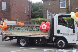 Premier Logs van with logo sign written on side, decorated in baloons in Adlington Carnival parade 2026